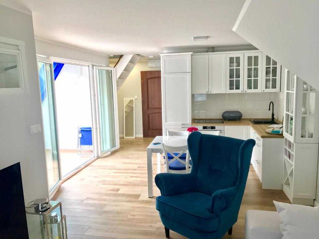 kuchnia z niebieskim krzesłem i stołem w obiekcie Apartamenty Platinum w Łukęcinie
