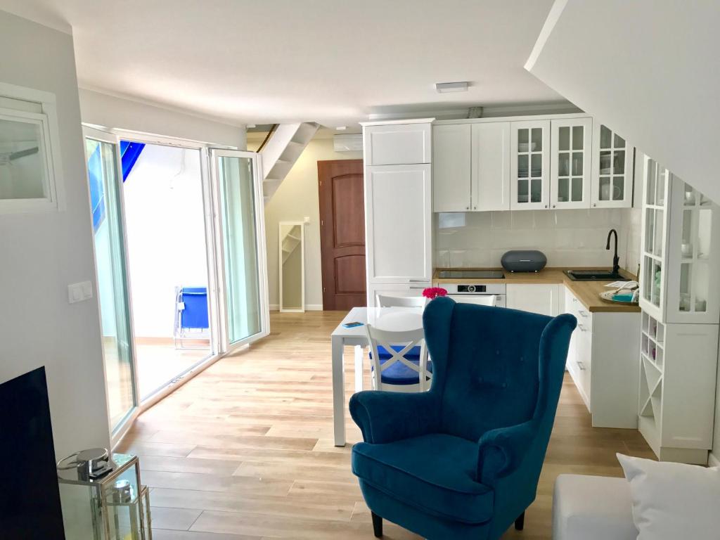 a kitchen with a blue chair and a table at Apartamenty Platinum in Łukęcin