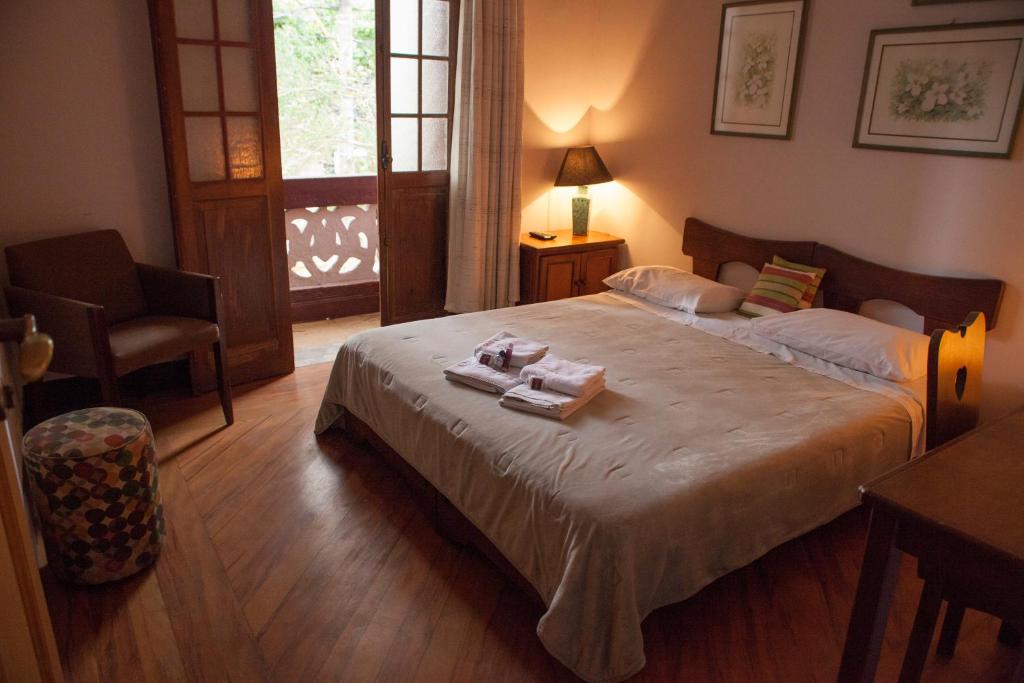 1 dormitorio con 1 cama grande y 2 toallas. en Pousada Zilah, en São Paulo