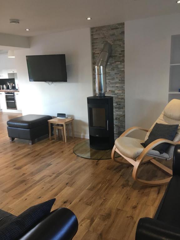 a living room with a fireplace and a tv at 35 Newvalley in Stornoway