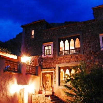 a large stone building with lights on it at night at Dar Sihamou in Tabant