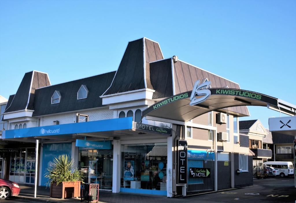 een winkel voor een gebouw met een bord erop bij Kiwi Studios Motel in Palmerston North