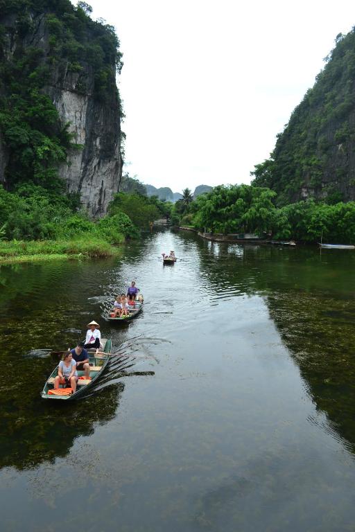 Mensen rijden in boten op een rivier. bij Tam Coc Smile Homestay in Ninh Binh