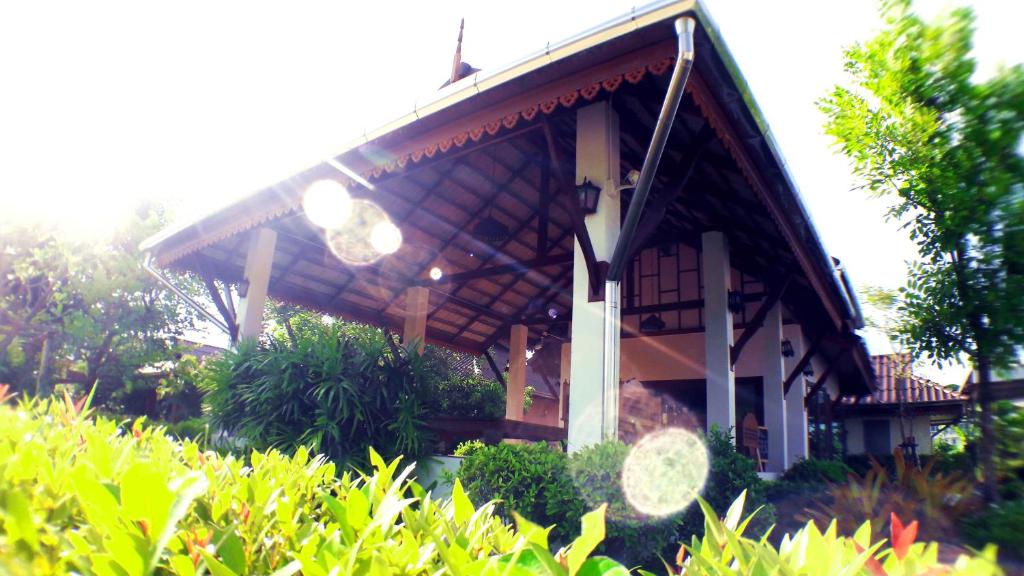 洛坤的住宿－坤那宏酒店，一座带灌木丛的大屋顶的房子