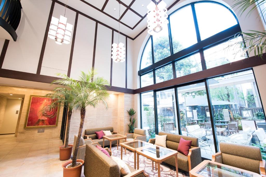 a lobby with chairs and tables and windows at Hotel Rose Garden Shinjuku in Tokyo