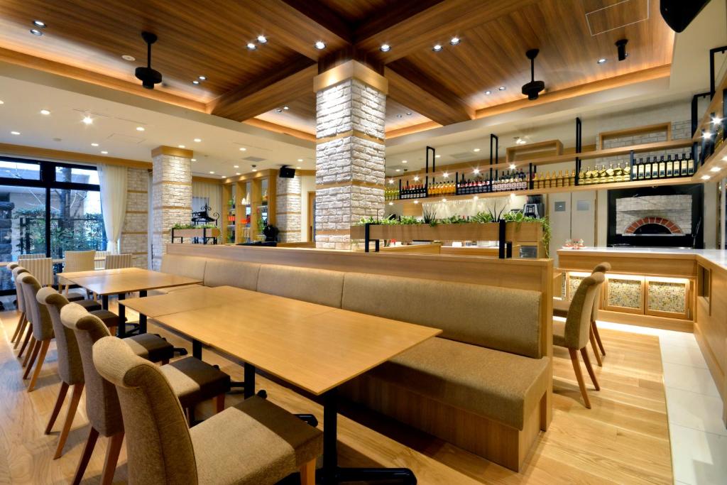 a restaurant with tables and chairs and a bar at Hotel Rose Garden Shinjuku in Tokyo