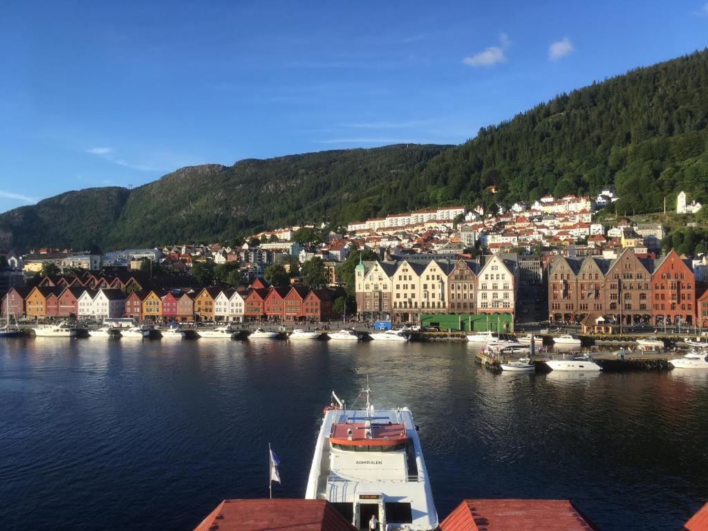 um barco em uma massa de água com casas e edifícios em Apartment with Beautiful View to Bryggen em Bergen