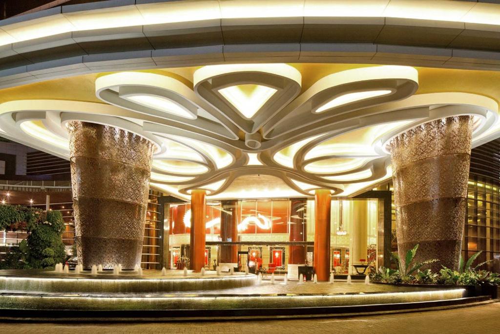 a lobby of a building with columns and lights at The Trans Luxury Hotel Bandung in Bandung