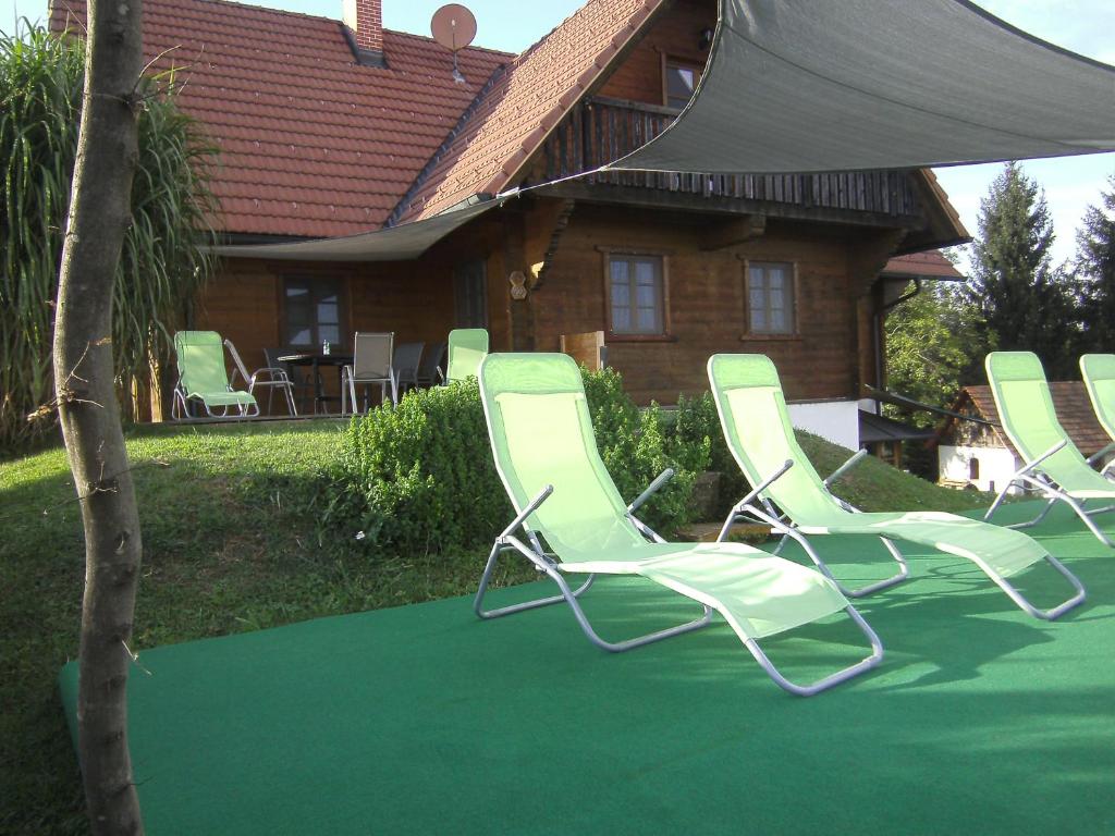 eine Gruppe von Gartenstühlen vor einem Haus in der Unterkunft Blockhaus Familie Raidl in Riegersburg