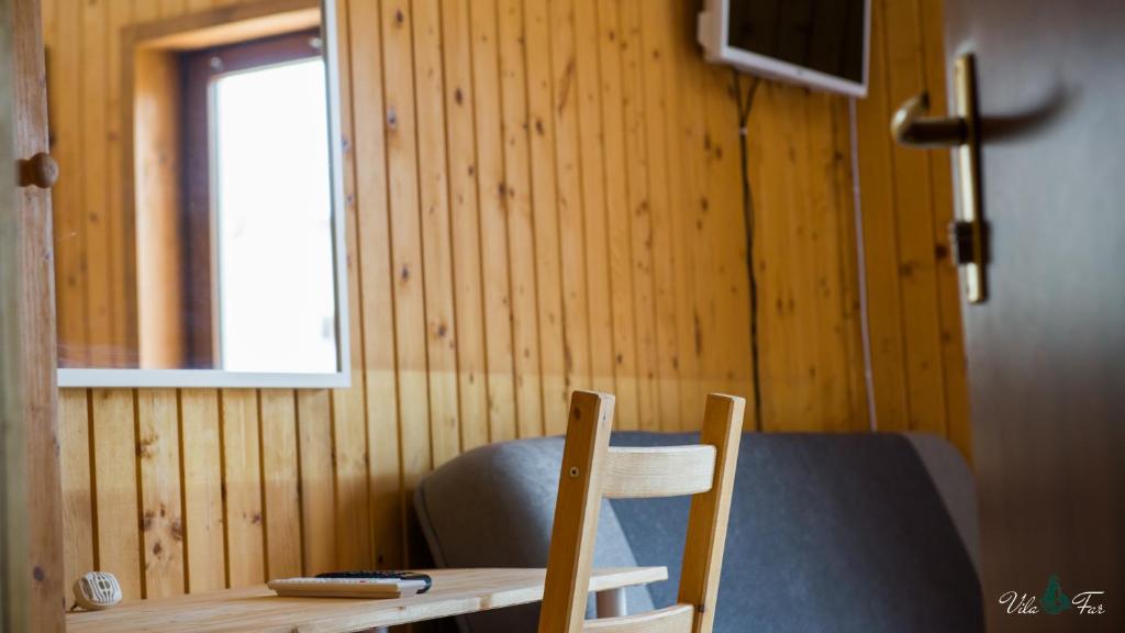 a wooden table and a chair in a room at Vila Far in Sfântu Gheorghe