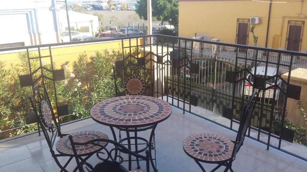 uma varanda com uma mesa e cadeiras. em Casa Vacanze LIBERTY em Licata