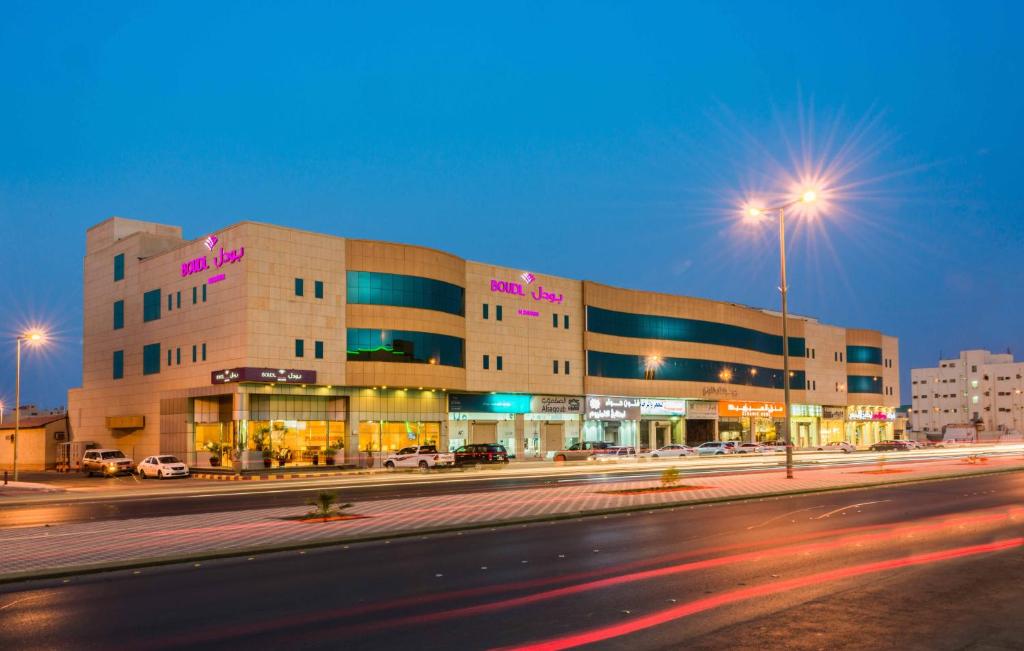 a large building on a city street at night at Boudl Buraydah in Buraydah