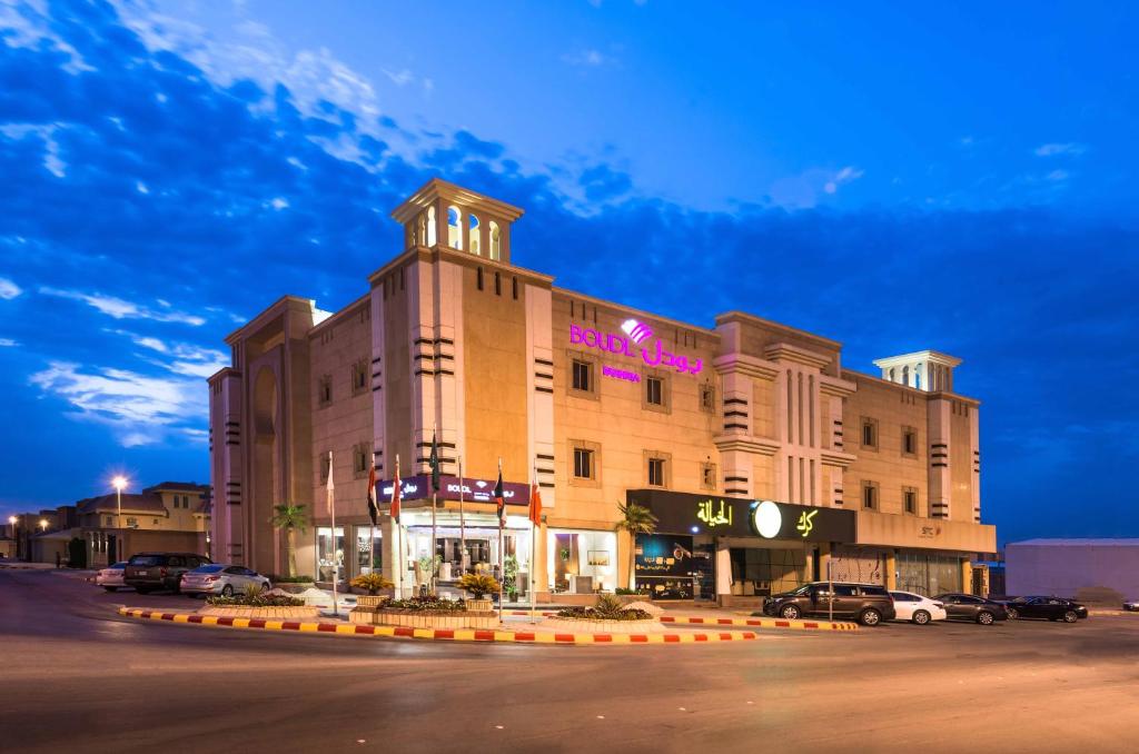 a building with a clock tower on top of it at Boudl Al Fakhria in Unayzah