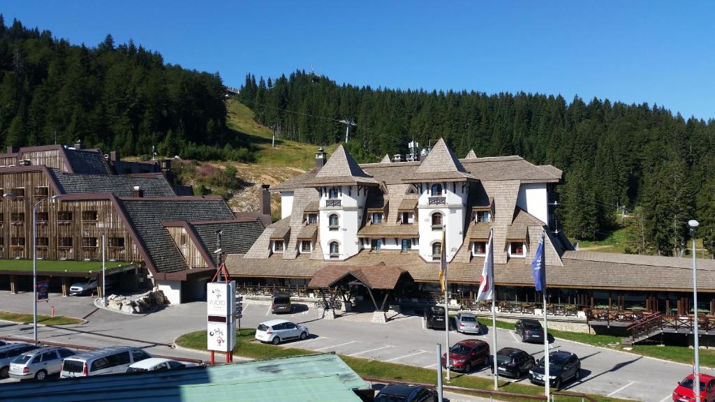 un gran edificio con coches estacionados en un estacionamiento en Apartment 216 NiM Vučko, en Jahorina