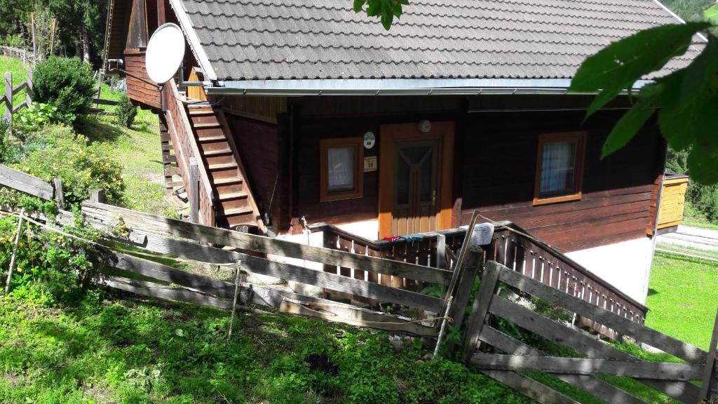 una casa in legno con una recinzione di fronte ad essa di Haus Kerschbaumer a Rangersdorf