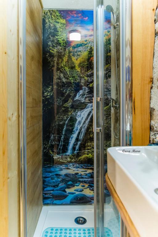 una ducha con un mural de una cascada en Casa Muro Ordesa, en Frajén
