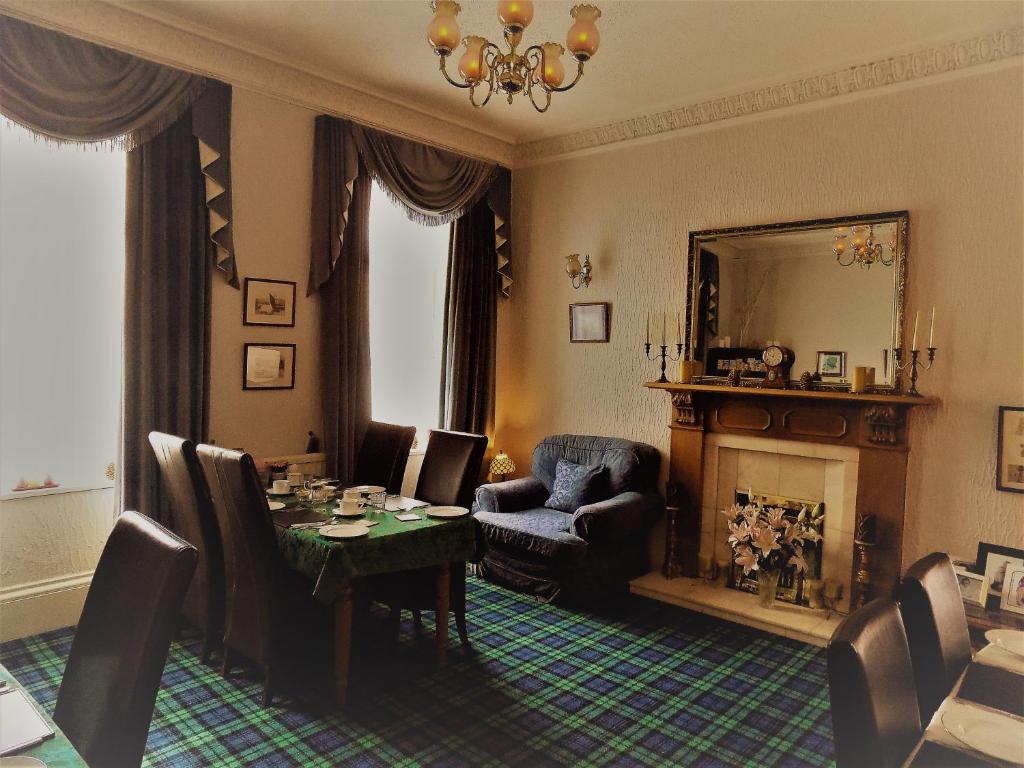 une salle à manger avec une table et une cheminée dans l'établissement Crawfords Guest house, à Peterhead