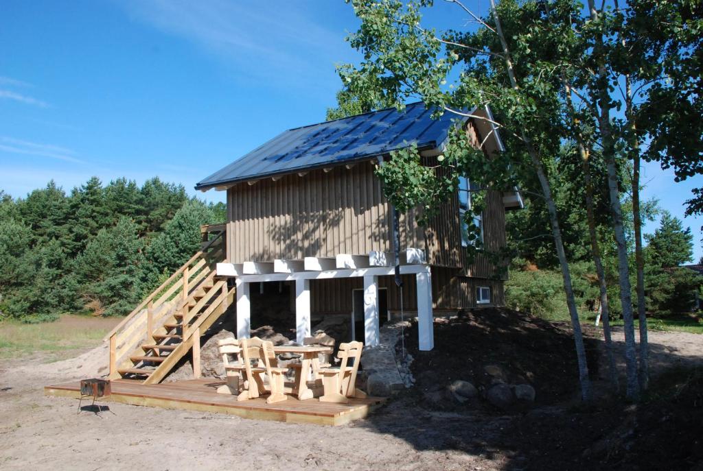 eine kleine Hütte mit einer Veranda und einem Solardach in der Unterkunft Pape Rogas in Pape