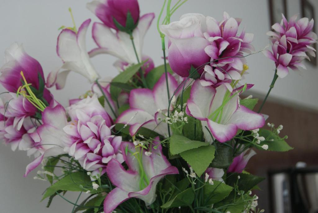 un bouquet de fleurs violettes et blanches dans un vase dans l'établissement Appart'Hôtel Les Rochers, à Auriol