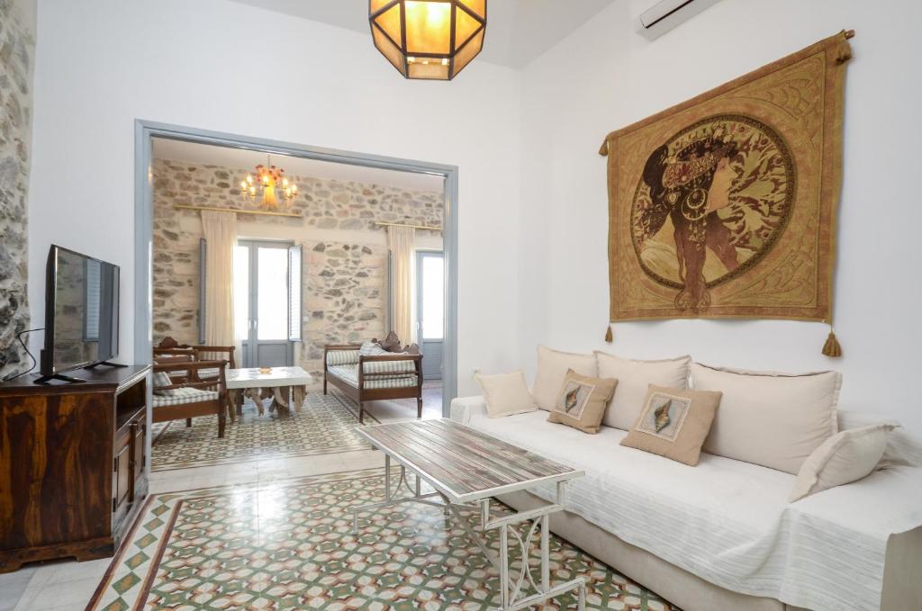 a living room with a white couch and a tv at Naxos Center Houses in Naxos Chora