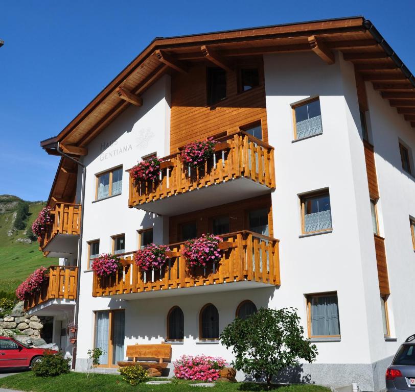 ein Gebäude mit Blumen auf den Balkonen in der Unterkunft Haus Gentiana in Samnaun