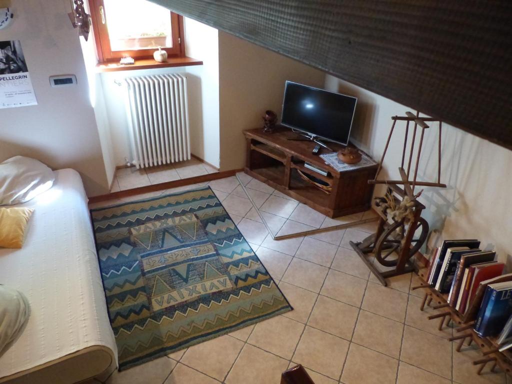 uma sala de estar com uma televisão, um sofá e uma mesa em B&B Vecchio Torchio em Bard