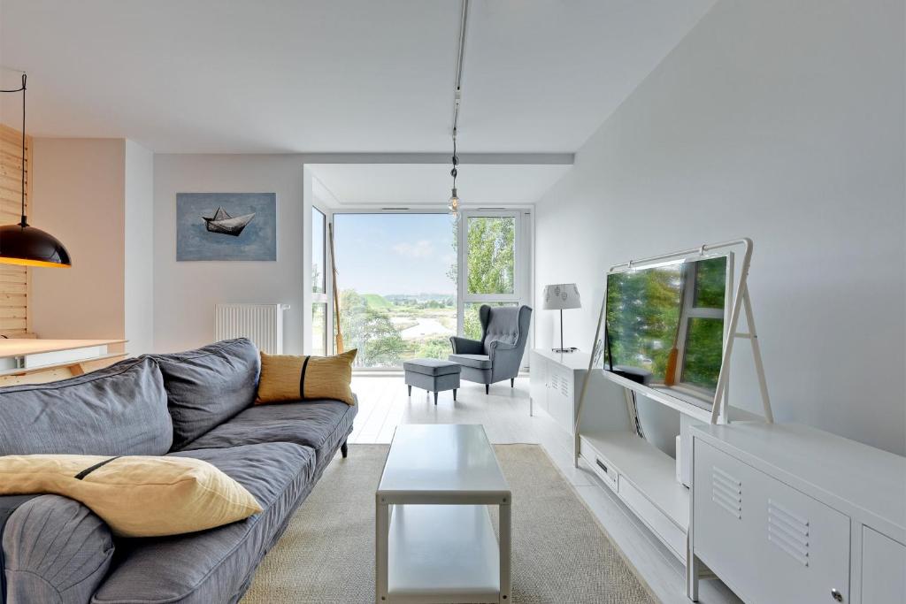 a living room with a couch and a table at NORDBYHUS Apartamenty Chmielna Park in Gdańsk