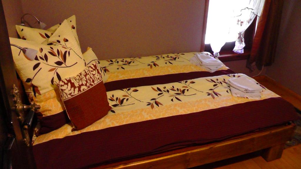 łóżko w sypialni z narzutą i poduszkami w obiekcie Rezydencja Maximus w mieście Karpacz