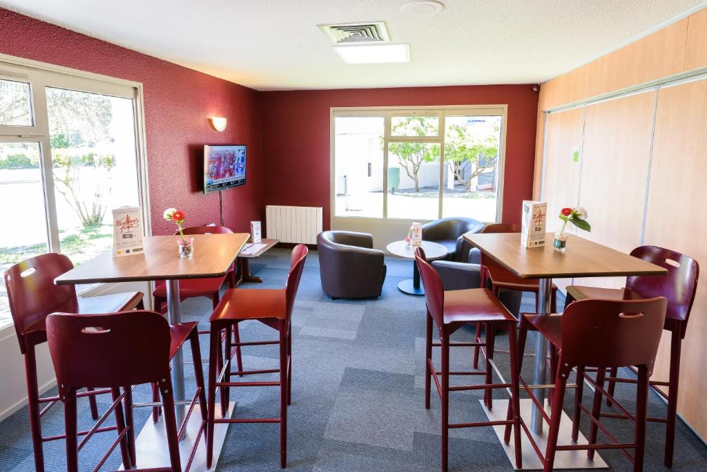 a restaurant with tables and chairs in a room at Campanile Toulouse Sesquieres in Toulouse