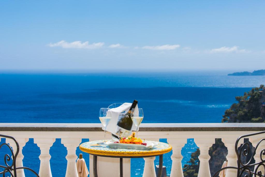 a table with a drink on a balcony with the ocean at Hotel Villa Gabrisa in Positano