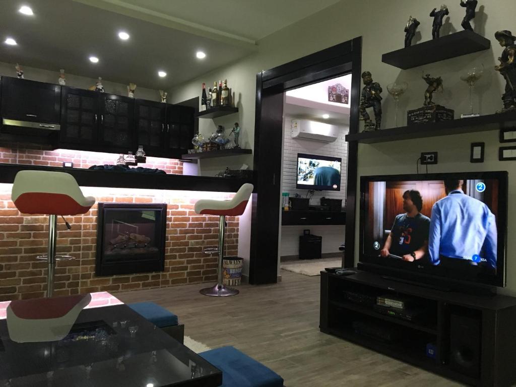 ein Wohnzimmer mit einem TV und einem Kamin in der Unterkunft Sporting Suite Studio in Alexandria
