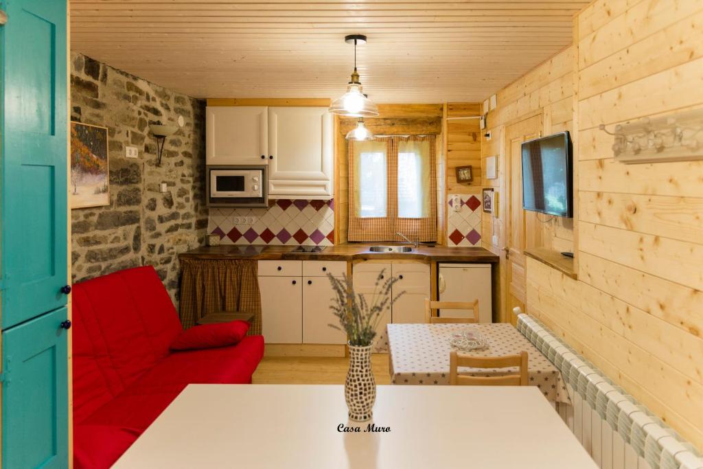 cocina y sala de estar con sofá rojo en Casa Muro Ordesa, en Frajén