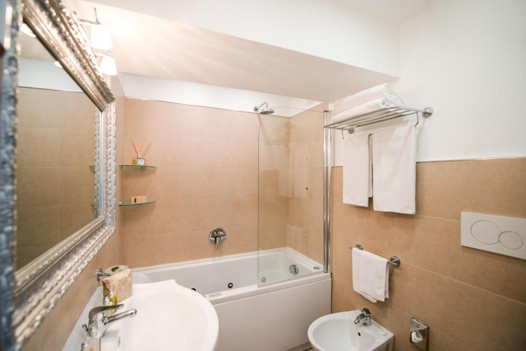 a bathroom with a sink and a tub and a toilet at Hotel Villa Gabrisa in Positano