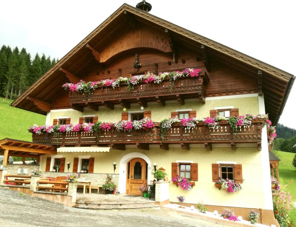 ein Haus mit Blumen auf dem Balkon in der Unterkunft Apartment Knablhof in Sankt Martin am Tennengebirge