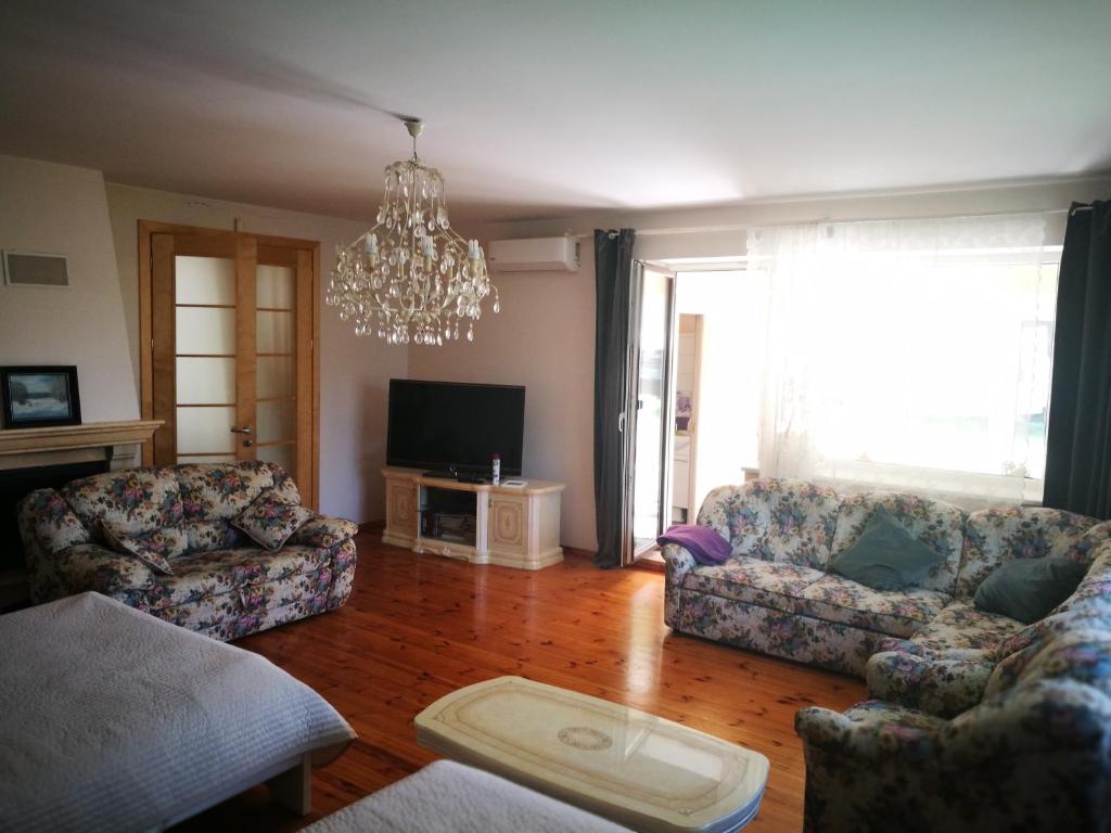 a living room with two couches and a chandelier at Irena Family House in Vilnius