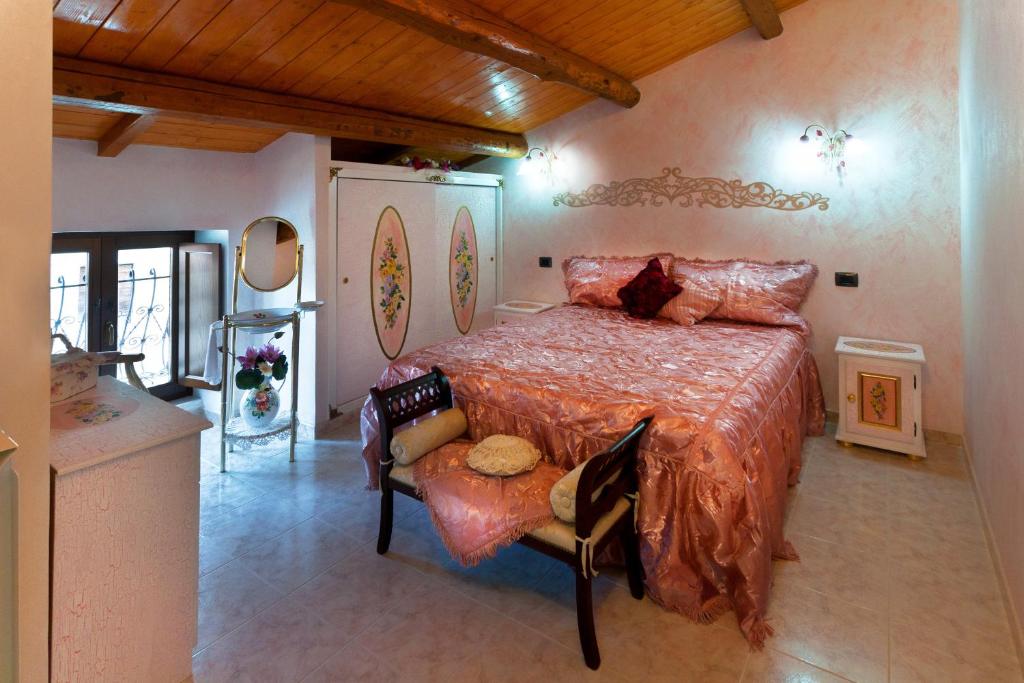 - une chambre avec un lit et une chaise dans l'établissement B&B Myosotis, à Introdacqua