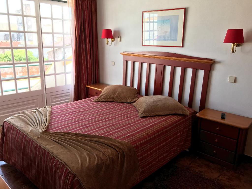 a bedroom with a bed with two pillows on it at Residêncial Colaço in Alcoentre