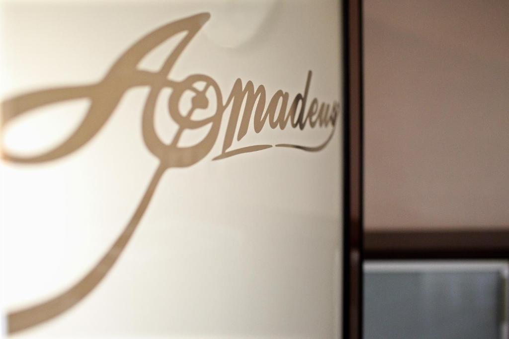 a sign on a wall with a pair of scissors at Amadeus in Łomża