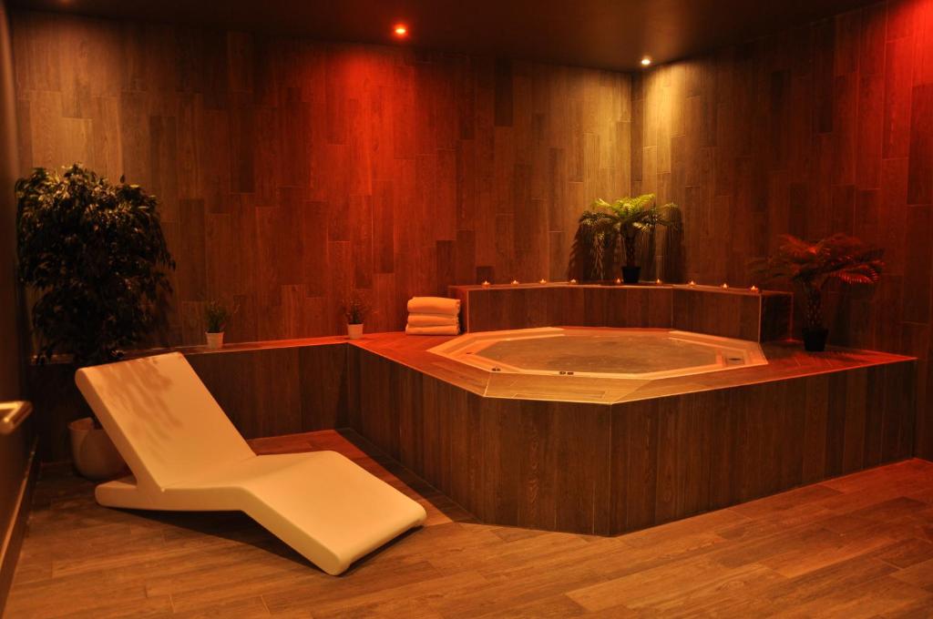 a jacuzzi tub with a chair in a room at Le Pic Blanc in L&#39;Alpe-d&#39;Huez