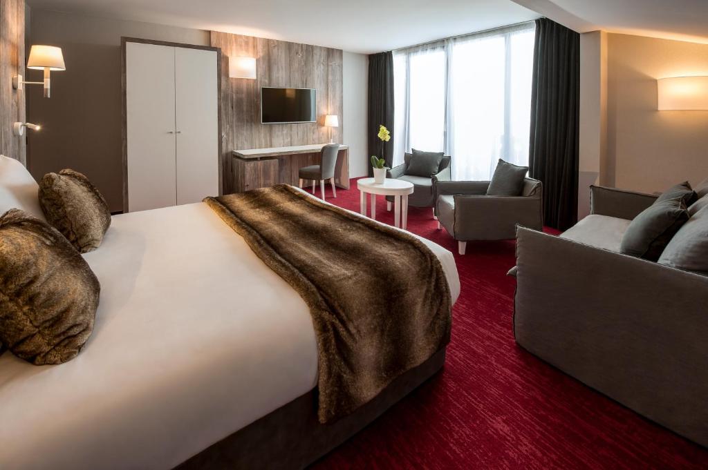 a hotel room with a large bed and a living room at Le Pic Blanc in L'Alpe-d'Huez
