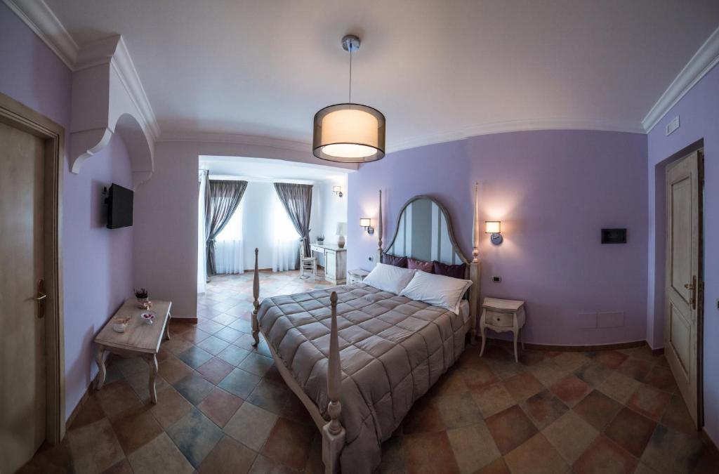 ein Schlafzimmer mit einem Bett, einem Tisch und einer Lampe in der Unterkunft Anima Antiqua Relais & Spa in Gioia Sannitica