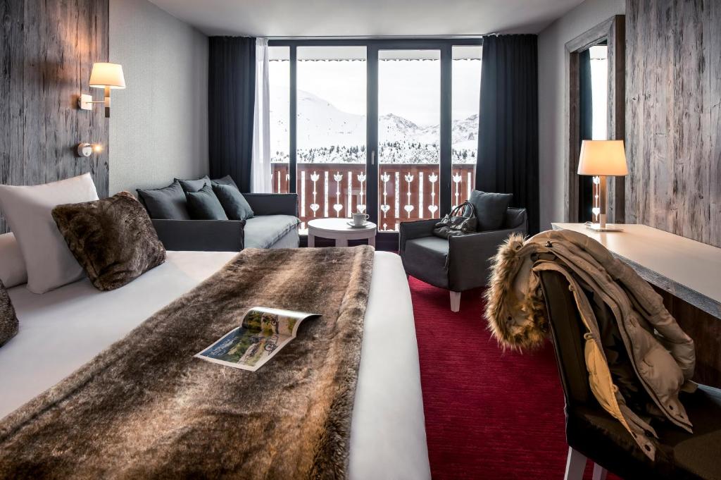 a hotel room with a bed and a balcony at Le Pic Blanc in L'Alpe-d'Huez