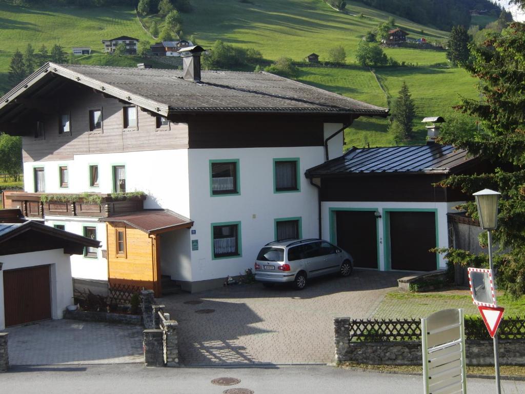 a car parked in front of a white house at Haus Kropf in Mittersill