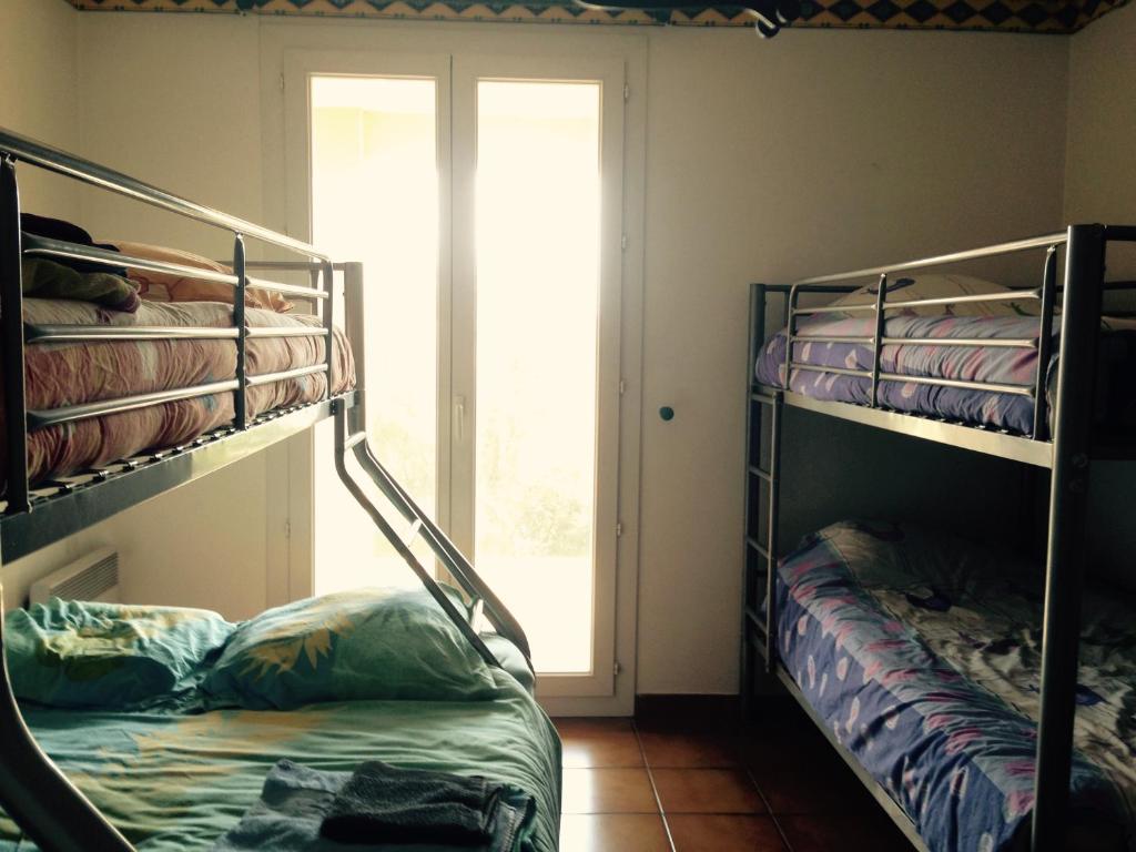 ポルティラーニュにあるVilla Ecluses Mediterraneeの二段ベッド2台と窓が備わる客室です。