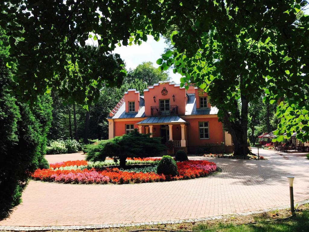 ein Haus mit einem Blumengarten davor in der Unterkunft Willa Różana in Nałęczów