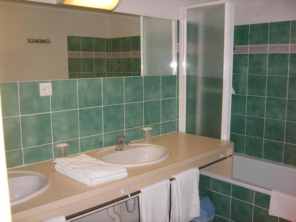 a bathroom with two sinks and a mirror at Hôtel De France in Chalabre