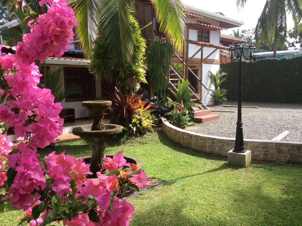 a garden area with flowers and a bench at Hotel Cabinas Tropical in Puerto Viejo