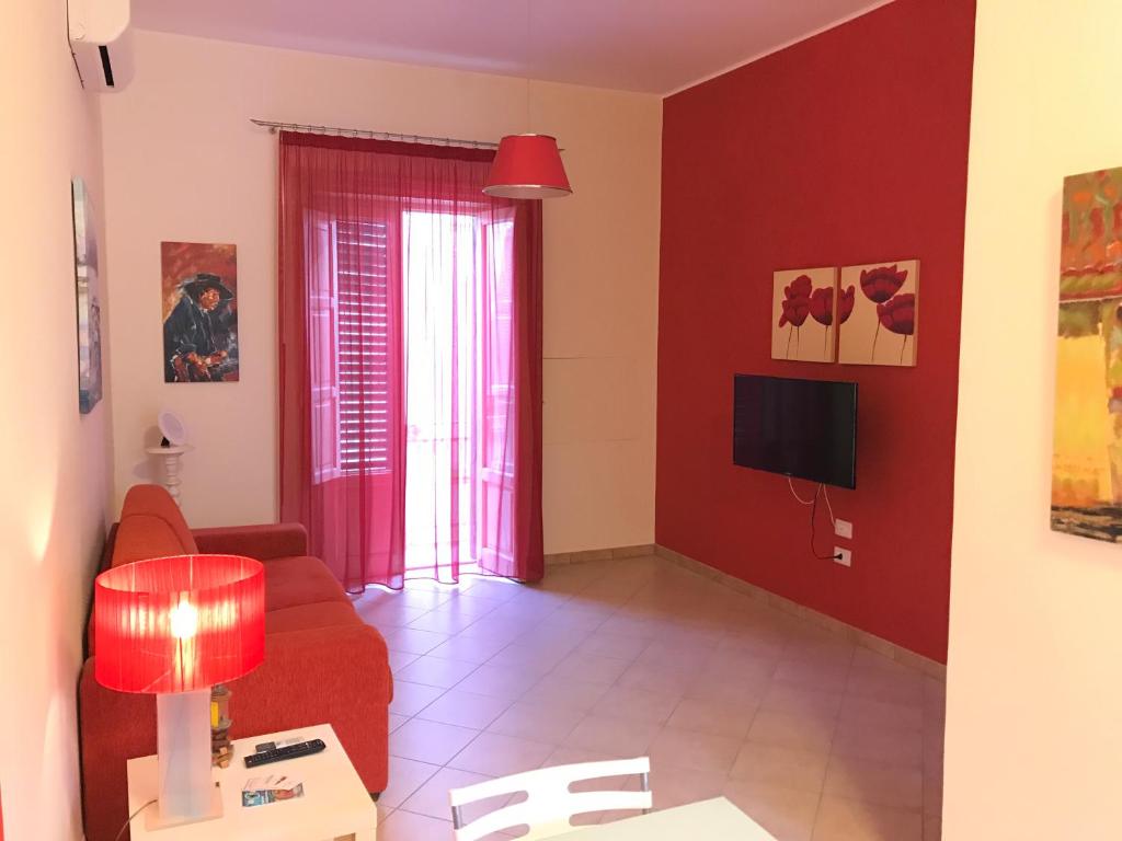 sala de estar con paredes rojas y sofá rojo en Palazzo Doria, en Marsala
