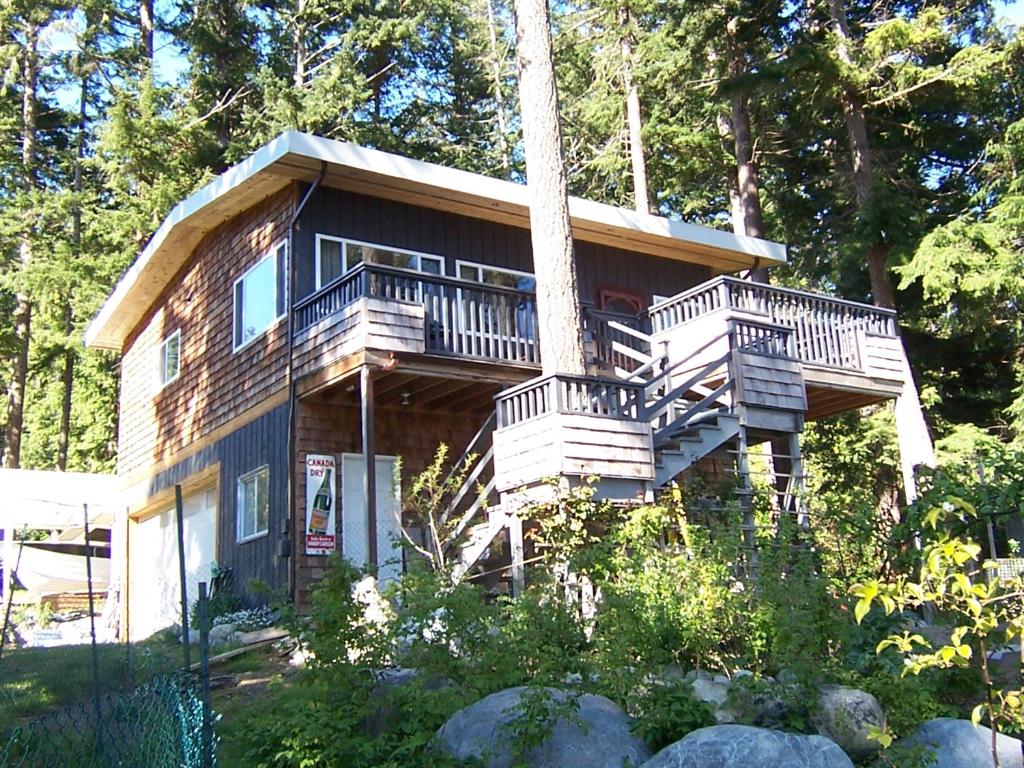 een groot houten huis met een balkon en een trap bij Malaspina Strait Cottage in Powell River