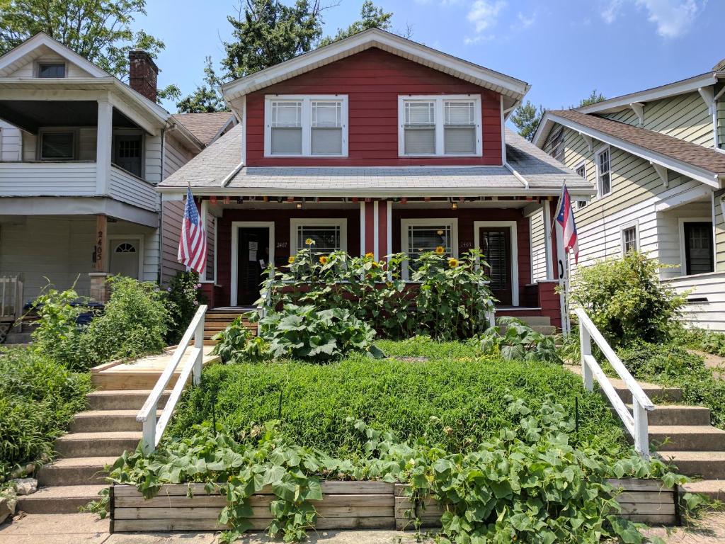 a red house with a garden in front of it at The Wayfaring Buckeye Hostel in Columbus